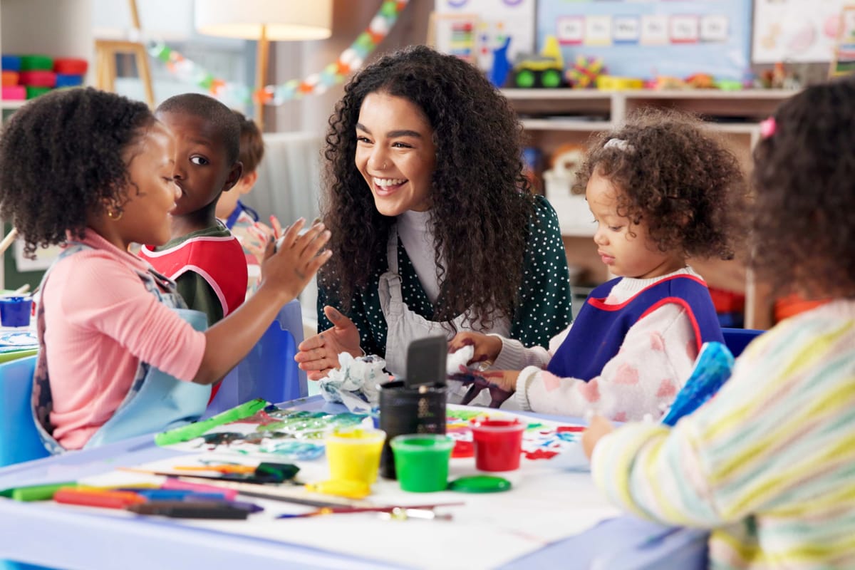 Education, children or painting with teacher in class for art, creative talent or motor skill development in preschool. Learning, students drawing or teaching happy kids for lesson or help with color