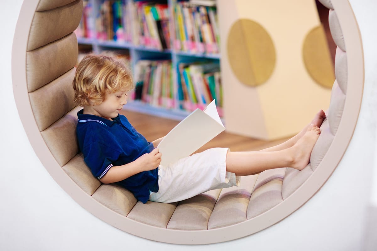 Child in school library. Kids read books. Little boy reading and studying. Children at book store. Smart intelligent preschool kid choosing books to borrow.