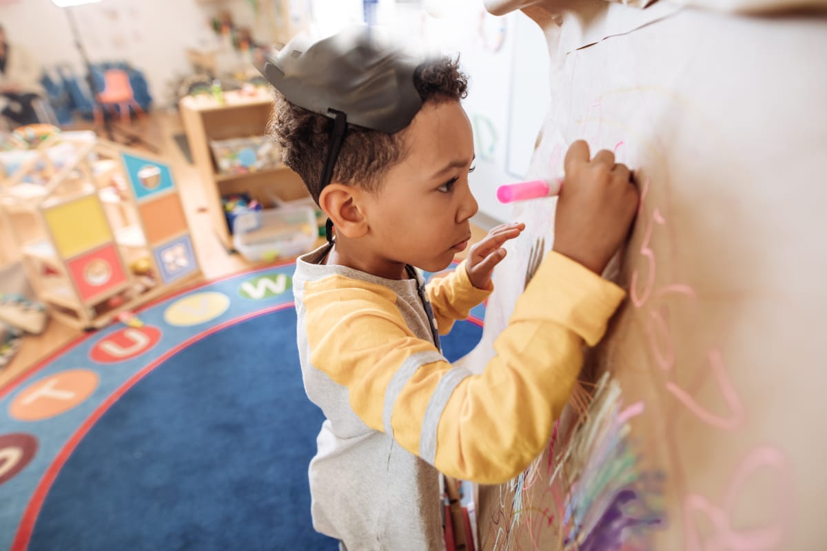 5 years old boy drawing in preschool