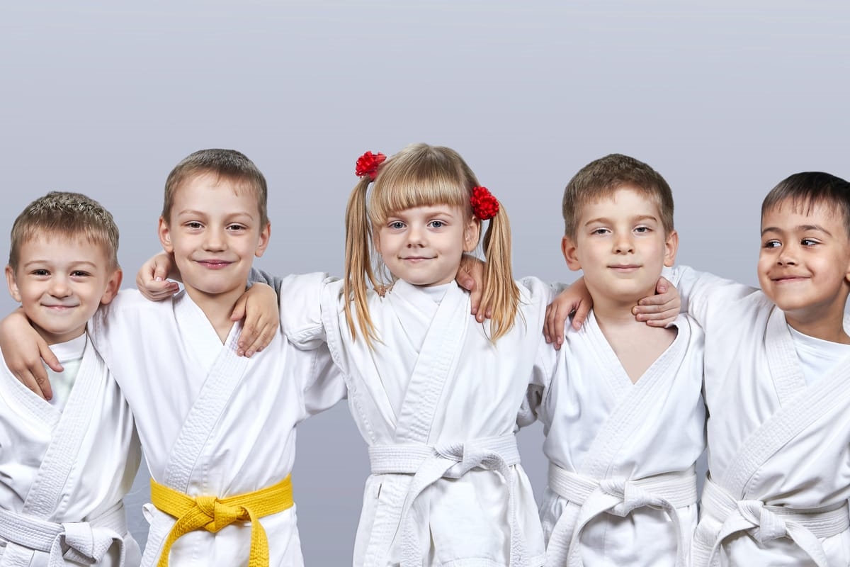 On a gray background little athletes in karategi