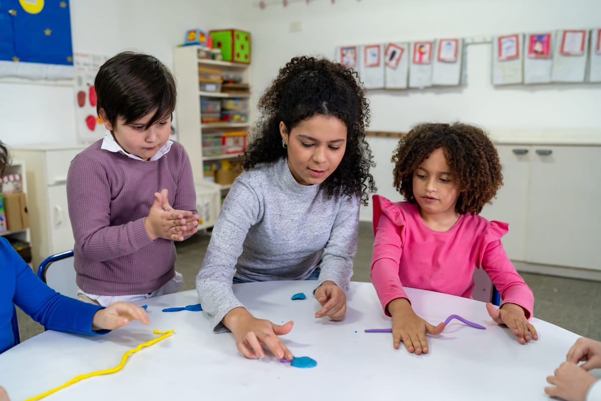 Diverse group of students following their teacher working with plasticine during class at school - Education concepts
